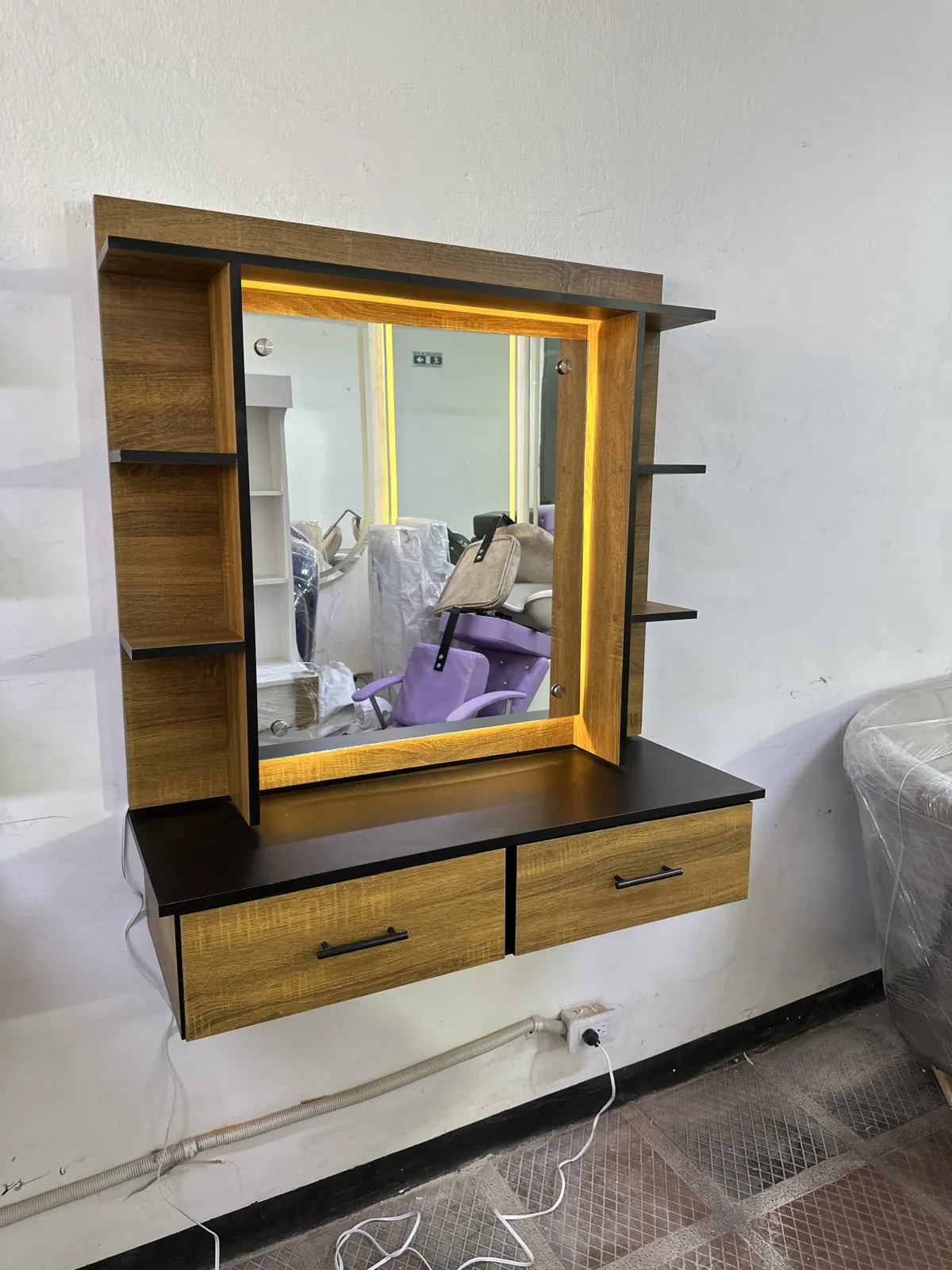 Tocador Milán LED flotante instalado en el taller de Muebles Pulido, con espejo iluminado y cajones en madera